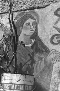 Particolare di pittura murale raffigurante una santa in preghiera.