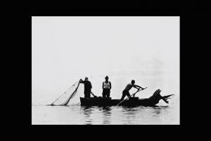 Pescatori su una barca mentre calano una rete.