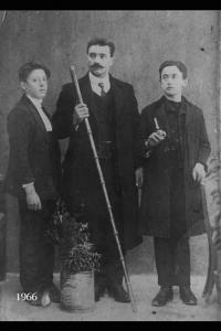 Ritratto di adulto con alpenstock e due giovani.