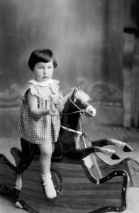 Ritratto infantile - Bambina su un cavallo a dondolo
