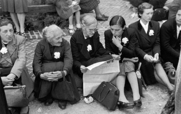 Referendum 1946 Repubblica o Monarchia. Milano - Piazza Castello - Comizio di Achille Grandi in favore della repubblica - Ritratto di gruppo: donne con fiore bianco all'occhiello - Giornale
