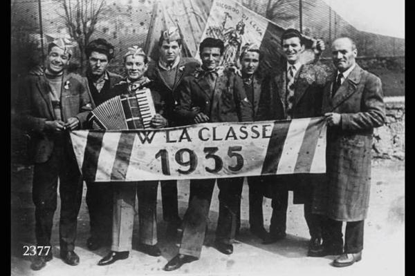 Coscritti classe '35. A destra Davide Maconi con il figlio  Giorgio. Il 3° da sinistra ha una fisarmonica. In primo piano striscione con scritta: "W LA CLASSE 1935".