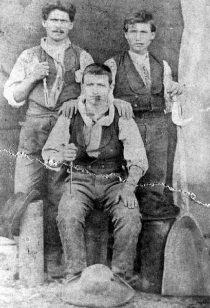 Tre uomini con una pala di legno, coltello, forchettone, roncola.