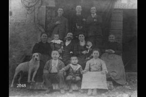 La famiglia Angiolini posa all'esterno di una casa con la scritta "1886" sopra l'ingresso.