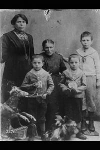 Angela Maconi con la madre Beatrice e i figli Primo e Secondo (gemelli) e Bernardino. In primo piano a sinistra, parte di un cavallo a dondolo.