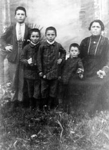 Angela Maconi con accanto un nipote e tre figli posano in esterno, con fondale.