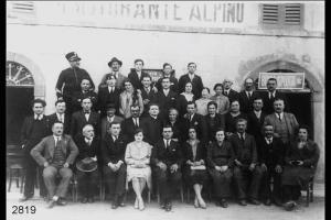 Ritratto di gruppo. Matrimonio di Giuseppe Valtolina e Rosetta Daina. Sullo sfondo, edificio con  scritta: "RISTORANTE ALPINO".