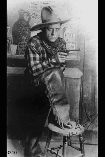 Ritratto di Giuseppe Rota, comparsa, in costume da cowboy con pistola in pugno.