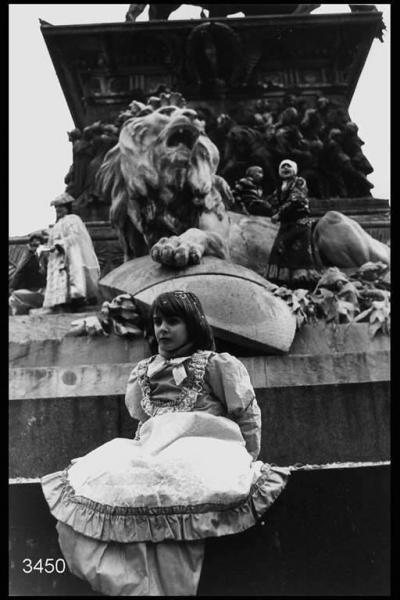 Carnevale ambrosiano. Basamento del monumento a Vittorio Emanuele: in primo piano una bambina in costume.