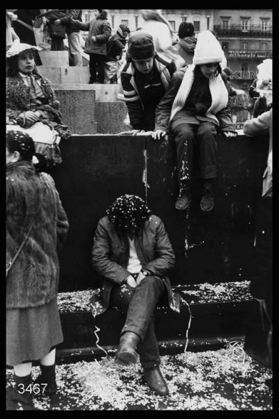 Carnevale ambrosiano, Piazza Duomo: uomo e bambini seduti ai  piedi del monumento a Vittorio Emanuele II.