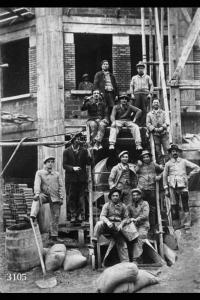 Ritratto di gruppo di muratori in un cantiere. Alla destra del personaggio seduto, in piedi, Luigi Bugada.