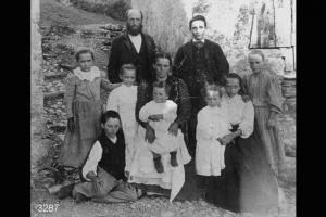 Ritratto di gruppo. Famiglia Antonio Vitari, davanti a un edificio rustico.