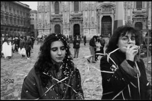 Carnevale ambrosiano. Due ragazze coperte di stelle filanti e coriandoli  in Piazza Duomo la mattina del sabato grasso.