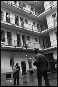 Suonatori di corno e trombone in una cortile di una casa di  ringhiera in via Sottocorno.