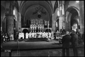 Festa di san Pietro Martire in Sant'Eustorgio: navata centrale. Lettura del Vangelo. Presbiteri all'altare durante la  celebrazione.