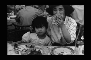 Famiglia cinese al ristorante. Madre e figlia a tavola. Immigrazione cinese.