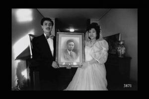 Usanza della tradizione cinese: prima del matrimonio gli sposi si fotografano con il ritratto dell'ultimo defunto della famiglia. Immigrazione cinese.