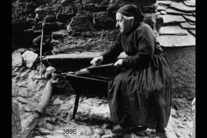 Cardatura della lana: donna anziana sta cardando la lana.