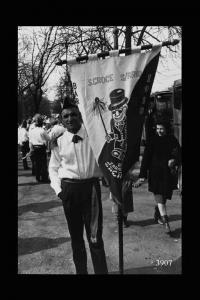 Uomo in costume con stendardo carnevalesco  con la scritta "S.Croce S/Arno 1918" attende la partenza del corteo ai  Bastioni di Porta Venezia.