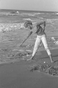 Rodi Garganico. Spiaggia. L'attrice Melina Mercouri disegna sulla sabbia con un ramo