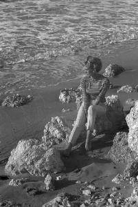 Rodi Garganico. Spiaggia. L'attrice Melina Mercouri ritratta seduta fra i sassi