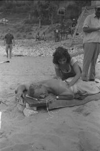 Rodi Garganico. Spiaggia. Set del film "La legge", diretto da Jules Dassin. Gina Lollobrigida massaggia il regista sulla schiena