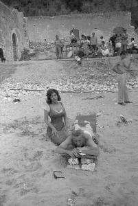 Rodi Garganico. Spiaggia. Set del film "La legge", diretto da Jules Dassin. Gina Lollobrigida seduta di fianco al regista