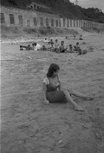 Rodi Garganico. Spiaggia. Set del film "La legge", diretto da Jules Dassin. Gina Lollobrigida, seduta sulla sabbia, si prepara a lanciare sassi nel mare