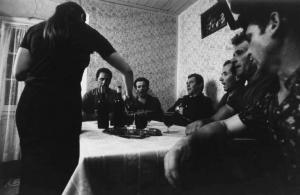 Canto popolare, gruppo di Santa Croce.  Canto in osteria: gruppo di uomini intorno a un tavolo  una donna serve del vino.
