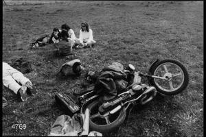 Parco Comunale. Giovani sul prato. Motocicletta in primo piano.
