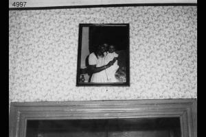Ritratto di donna con bambino appeso a una parete sopra una porta.