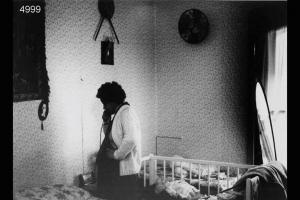 Interno di abitazione di una famiglia eritrea.  Donna incinta al telefono.