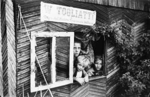 Milano. Baracche. Bambini  affacciati ad una piccola finestra; sopra la scritta "W Togliatti, Capo del Partito Comunista  Italiano".