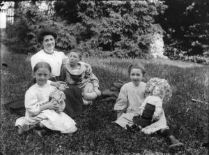 Ritratto di Carlo, Cioti e Tonia in giardino. Le due bambine tengono in braccio una bambola.