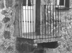 Cosrtuzione rurale.  Particolare: piccolo balcone con ringhiera in ferro battuto.