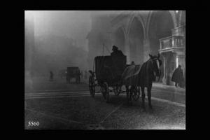 Cremona. Piazza del Comune in un giorno di nebbia. Due carrozze con cavalli in primo piano. Sullo sfondo i portici del palazzo comunale.