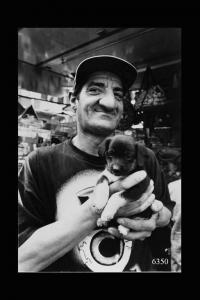 Milano, mercato di Piazza Martini. Uomo con cucciolo di cane.