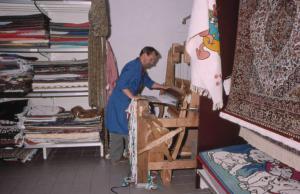 Tappeti esposti o piegati su ripiani nel negozio. I pezzotti di Arigna. (Luoghi della tradizione del lavoro).