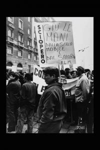 Piazzale Lodi. Manifestazione sindacale. Corteo: manifestante con cartello recante la scritta " Giù le mani dalla scala mobile e dal salario F.L.M."