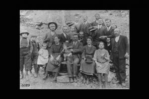 Famiglia valtellinese in posa ai piedi di un declivio roccioso