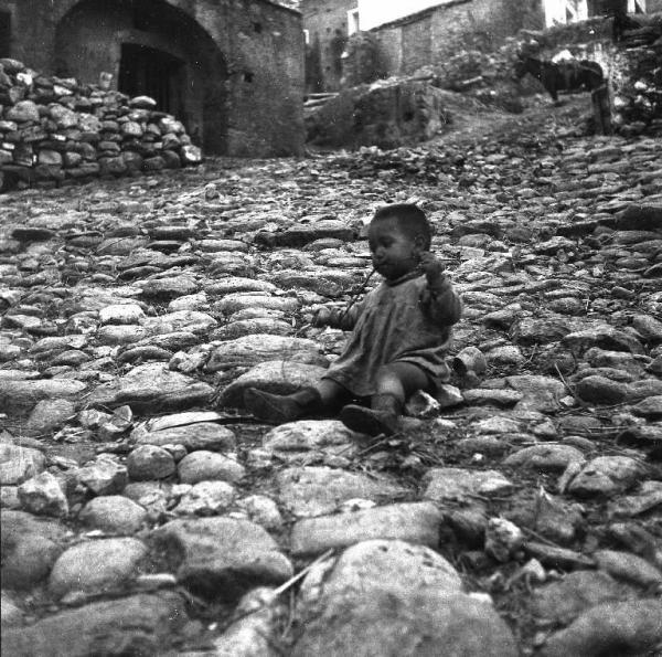 Melissa (Crotone) - Bambino piccolo seduto a terra in una strada