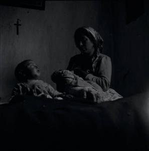 Melissa (Crotone) - Donna con neonato in braccio e altro bambino in una casa
