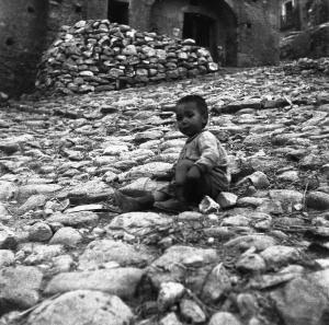 Melissa (Crotone) - Bambino piccolo seduto a terra in una strada