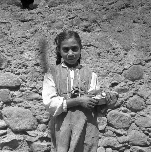 Melissa (Crotone) - Bambina con piatto in mano in una strada - Ritratto