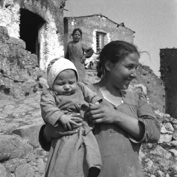 Melissa (Crotone) - Giovane donna con bambino in braccio in una strada