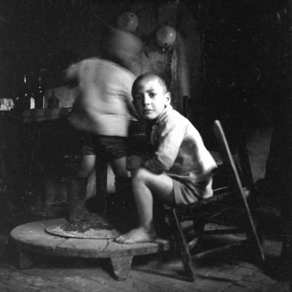 Melissa (Crotone) - Bambini intorno a un braciere nella cucina di una casa