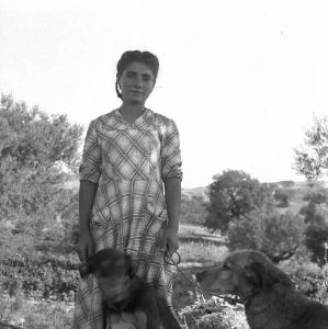 Melissa (Crotone) - Giovane contadina con cani in un campo - Ritratto