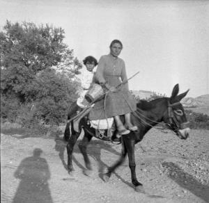 Melissa (Crotone) - Contadina con bambina su asino in una strada di campagna