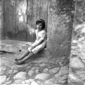 Melissa (Crotone) - Bambina seduta sull'uscio di una casa