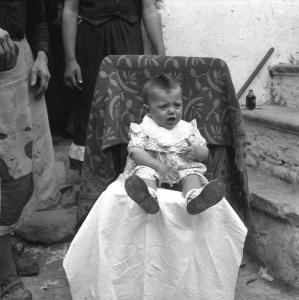 Melissa (Crotone) - Bambino piccolo seduto su una sedia all'esterno di una casa